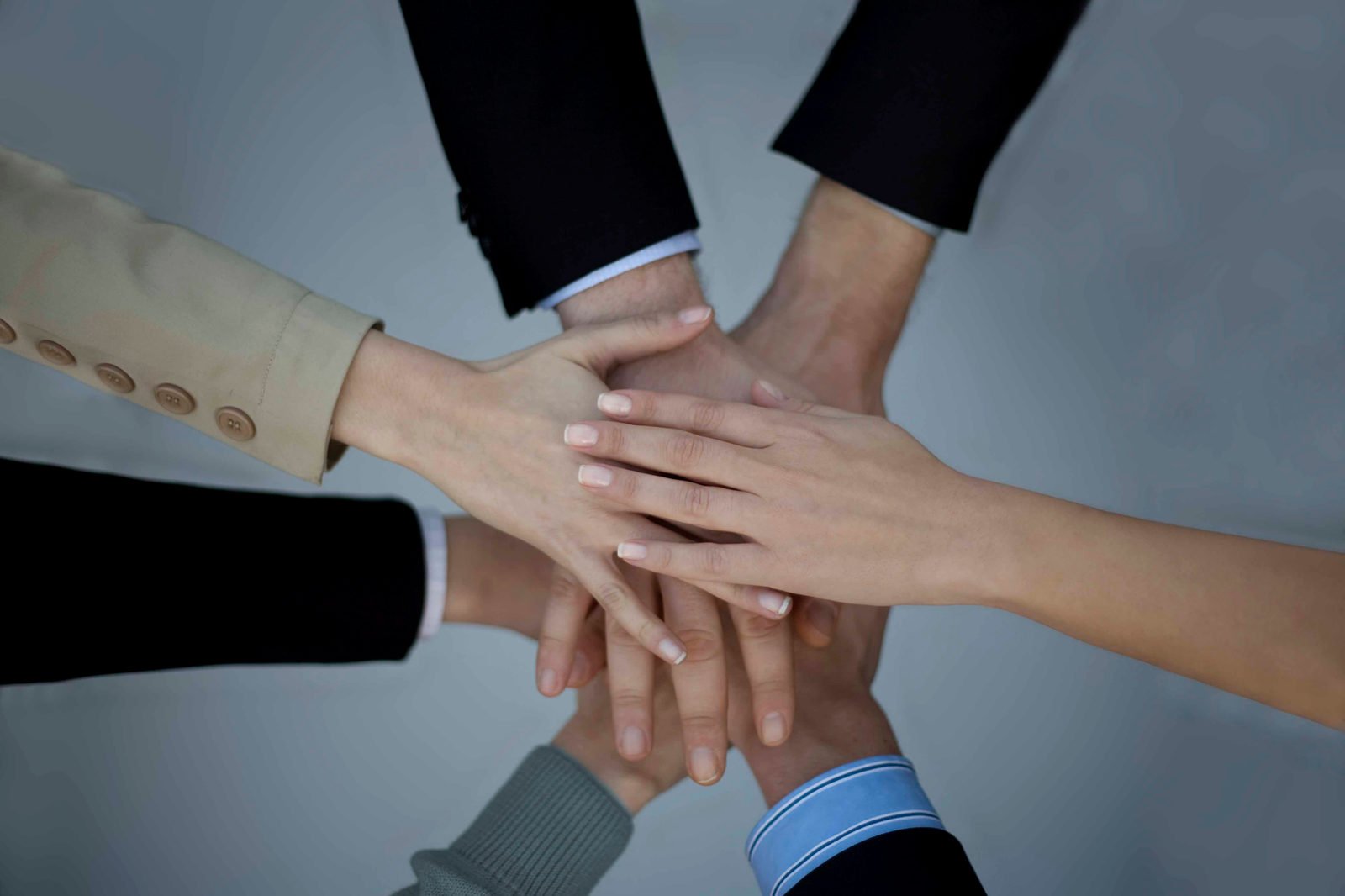 Equipo de trabajo uniendo las manos en señal de compromiso